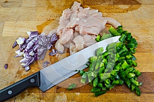 Chopped raw chicken meat, red onions and green peppers