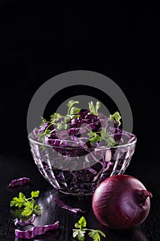 Chopped red cabbage and parsley in the bowl and nearby is the onion