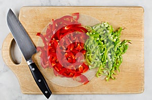 Chopped red and green bell pepper on cutting board