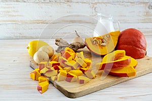 Chopped red kuri squash and ingredients for a vegetarian Thanksgiving or Halloween meal with coconut milk, ginger, potatoes and