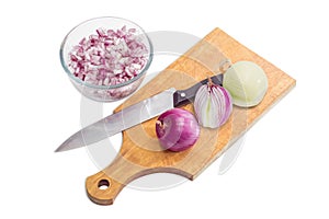 Chopped red onion, bulb onions and knife on cutting board