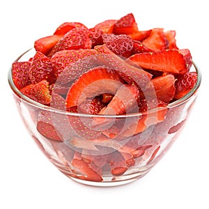 Chopped strawberries in transparent glas bowl isolated