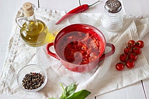 Chopped tomatoes with olive oil on a white background.