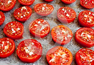 Chopped tomatoes with spices, garlic and olive oil on parchment paper. Close-up. Sun-dried tomatoes