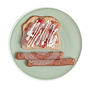 Chopped up frikadel with ketchup and mayonnaise on a piece of bread, on a plate