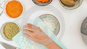 Chopped white onion close up on chopping board, lentils, chopped vegetables close up.