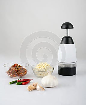 Chopper garlic tool with chopped garlic and chili isolated on white