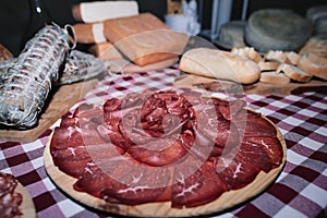 Chopping board of bresaola on a table of local local products