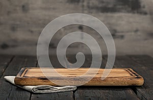 Chopping board on dark wooden background close up photo