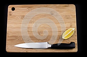 Chopping board, knife and lemon.