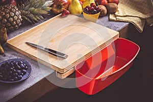 Chopping Board with Red Waste Container with Fresh Fruits Background