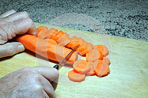 Chopping carrots on a wooden board.