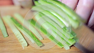 Chopping fresh cucumber for making vegetarian Sushi roll