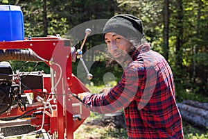 Chopping logs from trunks on trailer saw