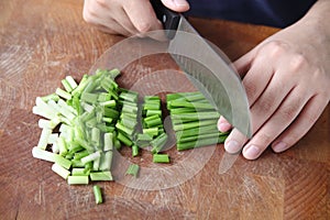 Chopping scallions on wood cutting board