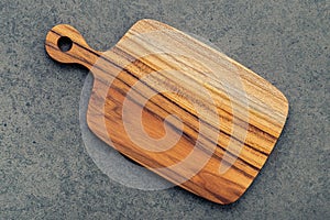 Chopping teak wood cutting board on dark stone background