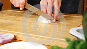 Chopping white onion on cutting board