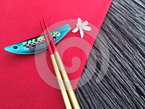 Chopstick on wood and red table cloth