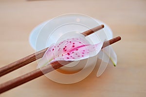 Chopsticks on bowl with lilium photo