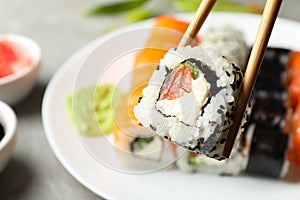 Chopsticks with delicious sushi roll. Japanese food