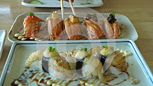 Chopsticks eating Japanese food aburi salmon nigiri with different sauces