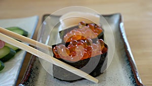 Chopsticks eating salmon roe sushi ikura maki Japanese food