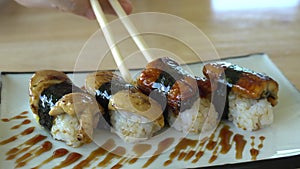 Chopsticks eating Sea eel and foie gras nigiri sushi Japanese fushion plate