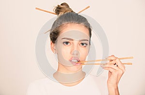 Chopsticks near sexy lips mouth. Sexy woman touch sensual lips with chopsticks. Sushi advertising.