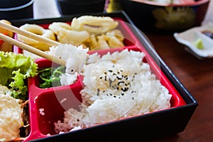 Chopsticks are pinch rice on bento set. Japanese food style.