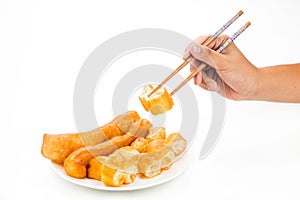 Chopsticks reaching for a piece of You Tiao, or fried bread stic photo