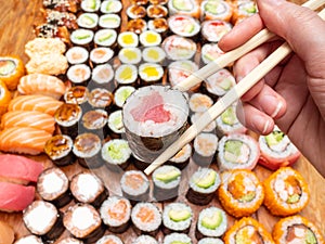 Chopsticks with tuna roll over assortment of sushi