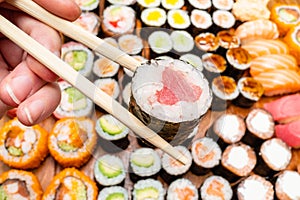 Chopsticks with tuna roll over various of sushi