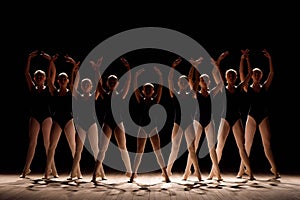 A choreographed dance of a group of graceful pretty young ballerinas practicing on stage in a classical ballet school.