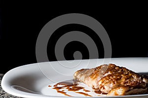 choripan, bread with sausage and pickles on a plate with dark background and copy space