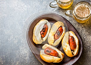 Choripan. Latin American Argentine and chilean food. Grilled chorizo sausages hot dogs served with beer, top view, stone
