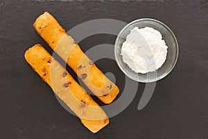 Chorizo breadstick and garlic cheese dipping sauce on black background