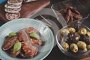 Chorizo, salami and olives on wooden table