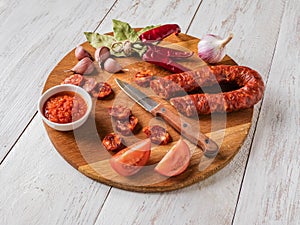 Chorizo sausage is sliced on a chopping board.