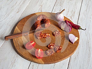 Chorizo sausage is sliced on a chopping board.