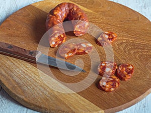 Chorizo sausage slices on white wooden background