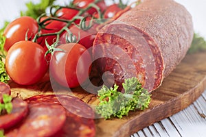 Chorizo sausage. Spanish traditional chorizo sausage with fresh tomatoes.  Served on an olive plate