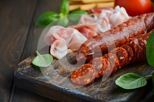 Chorizo sausage. Spanish traditional chorizo sausage and ham with fresh herbs and tomatoes.
