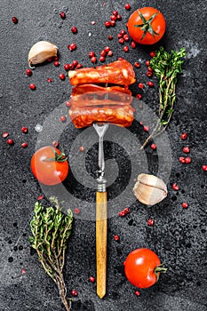 Chorizo sausage thin cut. Spanish salami with spices, paprika, pepper. Spicy food. Black background. Top view