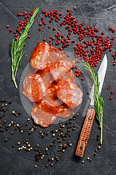 Chorizo sausage thin cut. Spanish salami with spices, paprika, pepper. Spicy food. Black background. Top view