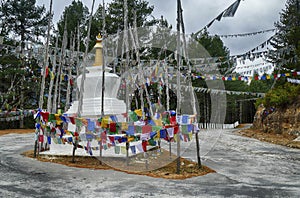 Chorten and  prayer flags  in the snow repeating mantra