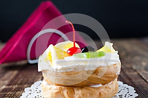 Choux pastry with fruit on a wooden background