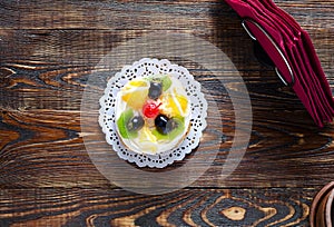 Choux pastry with fruit on a wooden background
