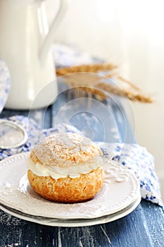 Choux pastry stuffed with cream on two white saucers