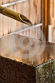 A Chozubachi - Tsukubai, a bamboo pipe dropping water on a flat stone, Kanazawa, Japan