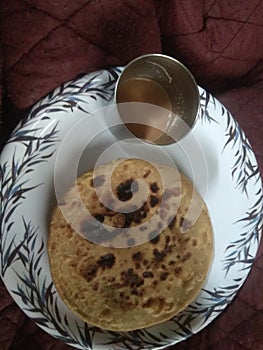 Chpati  with tee on the a white plate it`s like Indian morning food